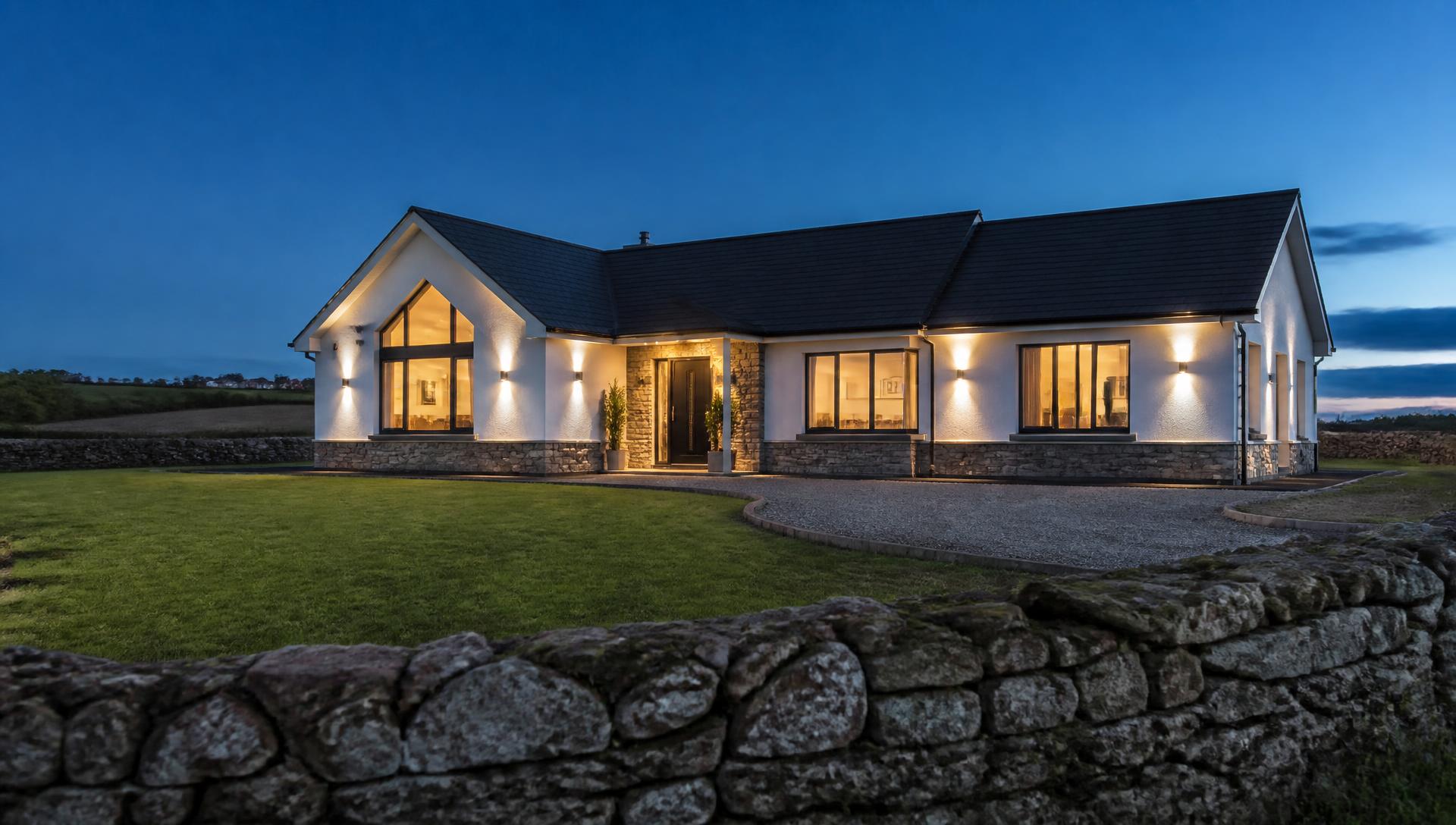 Contemporary Irish home at dusk with warm interior lighting